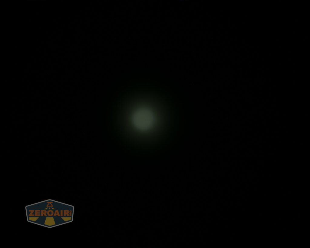 A dim, circular greenish light appears in the center of a black background. A small ZeroAir logo is visible in the bottom left corner.