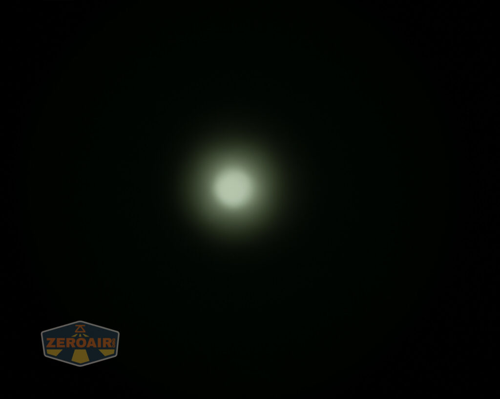 A round, white light source is centered against a dark background, creating a soft halo effect. A ZEROAIR logo appears in the lower left corner.