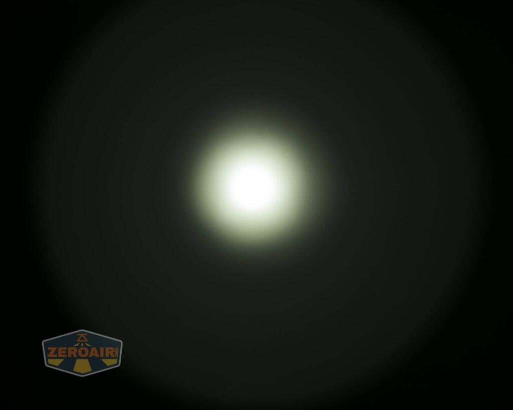 A bright, circular white light source is centered against a dark background, creating a gradient halo effect. A small logo with the text ZEROAIR appears in the bottom left corner.
