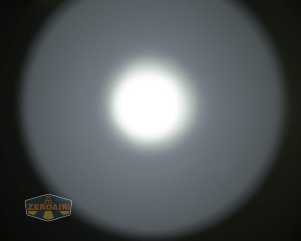 A bright, circular white light is centered in the image, surrounded by a gradient halo fading to dark. In the bottom left corner, there is a small logo with the text ZEROAIR inside a badge shape.