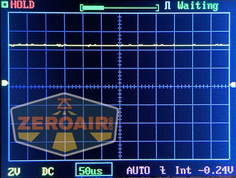 Oscilloscope screen displaying a mostly flat yellow waveform with minor fluctuations. The status reads Waiting, and settings at the bottom show 2V, DC, 50µs, and -0.24V. The ZeroAir logo and Lumintop GT Nano Brass are overlaid.