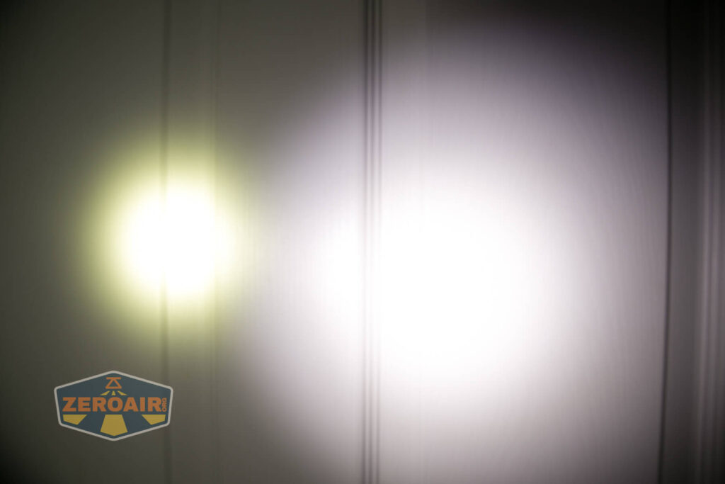 Two flashlight beams, one yellowish and one white, are projected side by side on a wall with vertical lines. A logo reading ZEROAIR appears in the lower-left corner of the image.