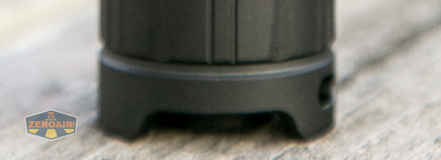 Close-up of the base of a black cylindrical object with a cutout section, resting on a wooden surface. The ZeroAir logo is partially visible in the bottom left corner.