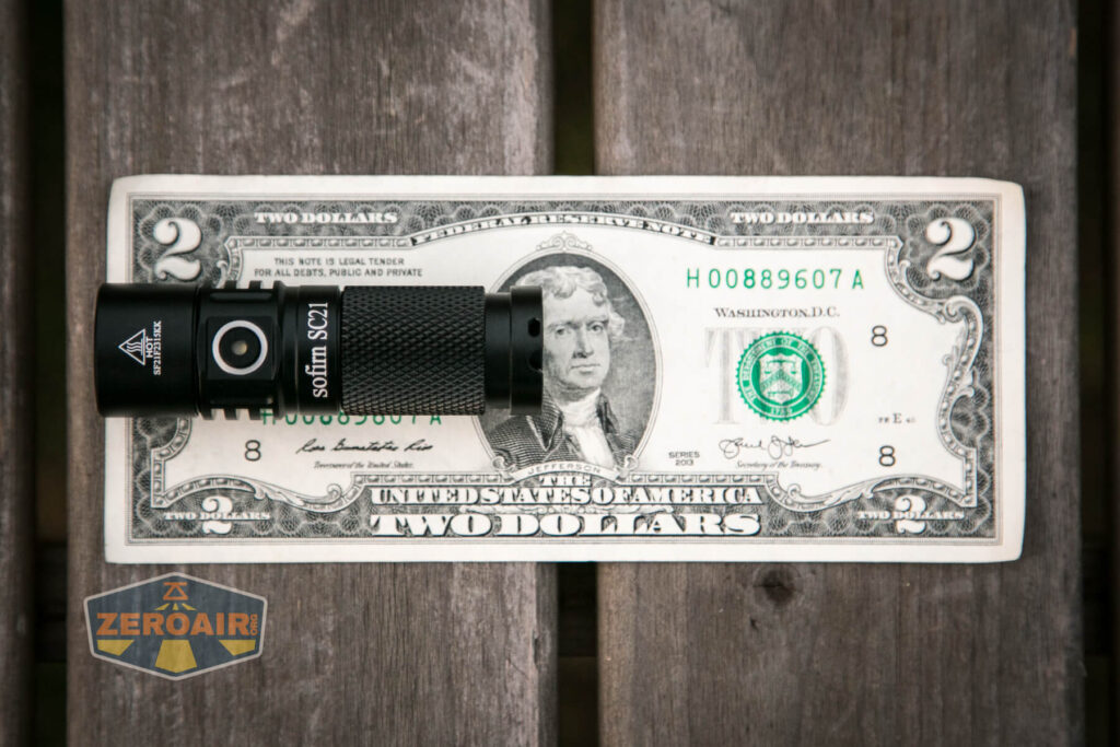 Sofirn SC21 flashlight on two-dollar bills