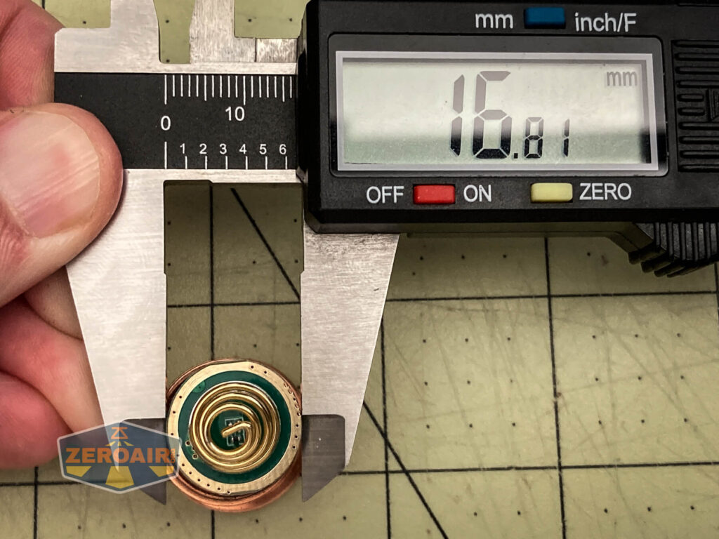 A digital caliper measures the diameter of a WWLZ Bamboo Small round object, displaying 16.01 mm. The bamboo item rests on a gridded surface while a hand securely holds the caliper.