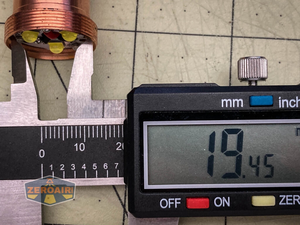 A digital caliper measures the diameter of a WWLZ Bamboo Small cylindrical object with LEDs on one end, displaying 19.45 mm. The background is a gridded surface, and a ZeroAir logo is partially visible.