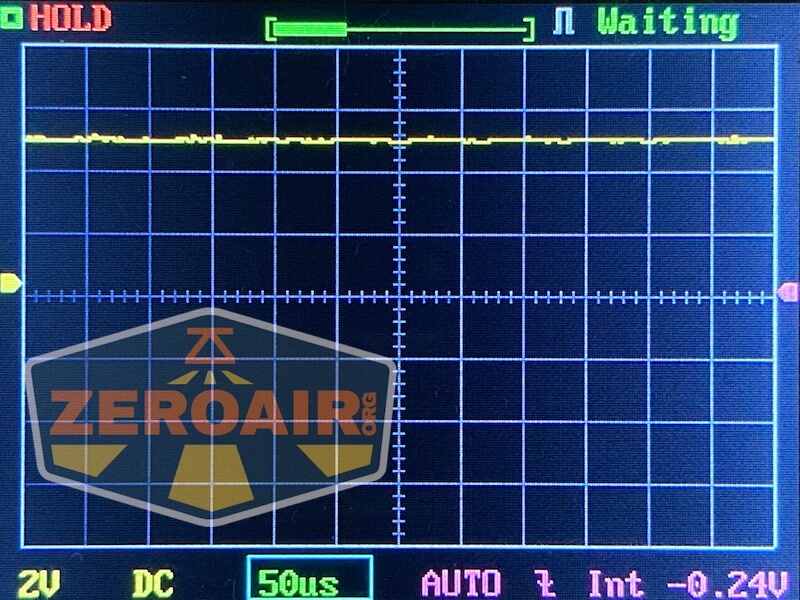 A digital oscilloscope screen displays a mostly flat yellow waveform, with the status Waiting in the top right. The bottom shows settings: 2V, DC, 50µs, AUTO, and -0.24V. The ZeroAir.org logo overlays the left side.