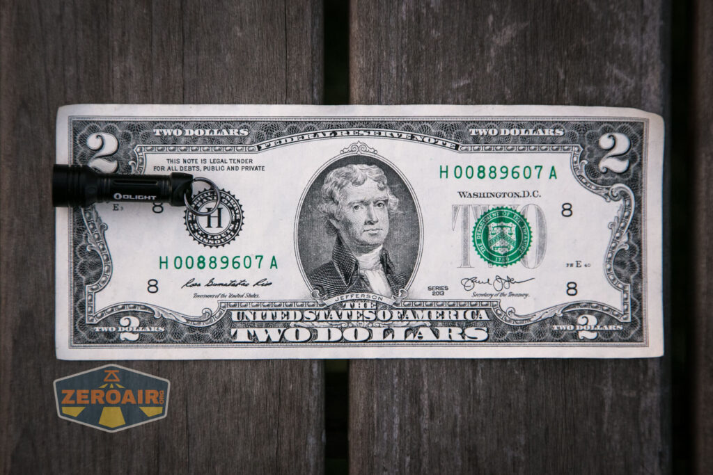 Olight X9R Cell on two-dollar bill