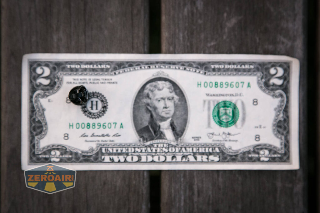 Olight X9R Cell on two-dollar bill