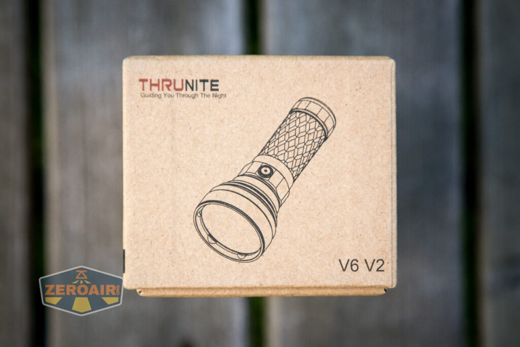 A cardboard box with a line drawing of a flashlight on the top. The text reads THRUNITE Guiding You Through The Night and V6 V2. A ZEROAIR logo appears in the bottom left corner.