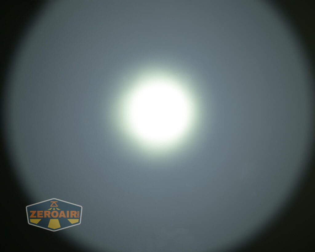 A bright white circular light is centered against a darker background. The logo “ZEROAIR” appears in yellow and gray in the bottom left corner.