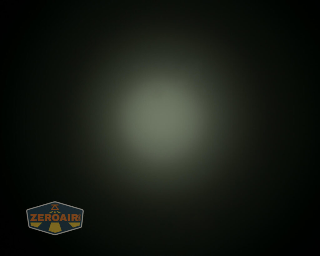 A soft, circular beam of light is centered on a dark background, creating a vignette effect. The ZeroAir logo appears in the bottom left corner of the image.