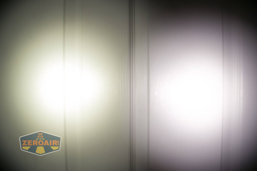 Two flashlight beams, one yellowish on the left and one white on the right, are projected onto a white paneled surface. The ZeroAir logo is visible in the lower left corner of the image.