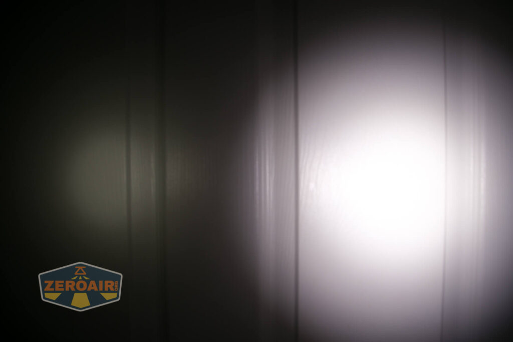 A beam of light from a flashlight shines on a white paneled surface in an otherwise dark setting. A logo with the text ZEROAIR appears in the lower left corner.
