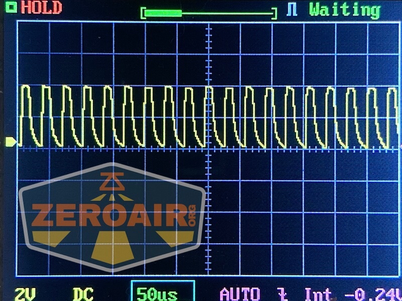 Oscilloscope screen displaying a repeating square wave signal with labeled axes. The word HOLD appears in red; Waiting is shown in blue-green at the top. A ZeroAir watermark is present across the lower left.