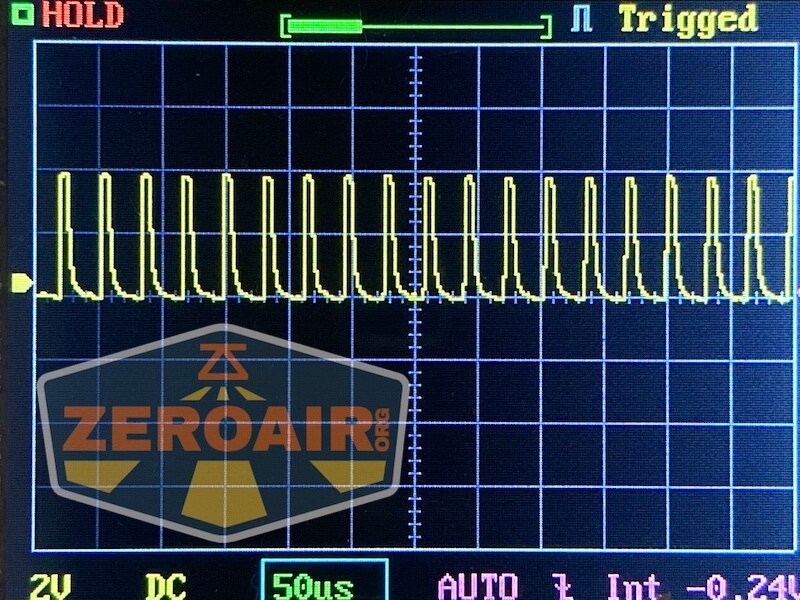 An oscilloscope screen shows a repeating square wave signal. The settings indicate 2V per division vertically and 50 microseconds per division horizontally. The display includes the ZeroAir.com watermark.