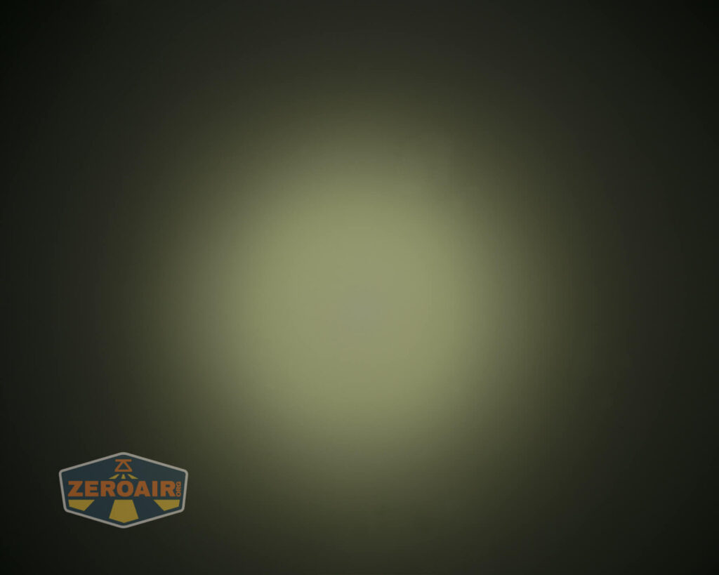 A circular gradient of greenish-yellow light is centered on a dark background. The lower left corner features a semi-transparent logo with the text ZEROAIR.