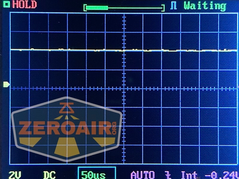 Oscilloscope screen shows a mostly flat yellow waveform along the zero line, with the status HOLD in red and Waiting in blue. Gridlines, labels, and the ZeroAir.org logo are also visible.