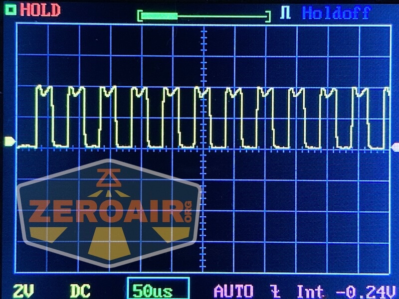 Oscilloscope screen displaying a repetitive square wave signal pattern. The display shows grid lines, voltage and time settings, and the word ZEROAIR.org with a logo overlaid in the bottom left corner.