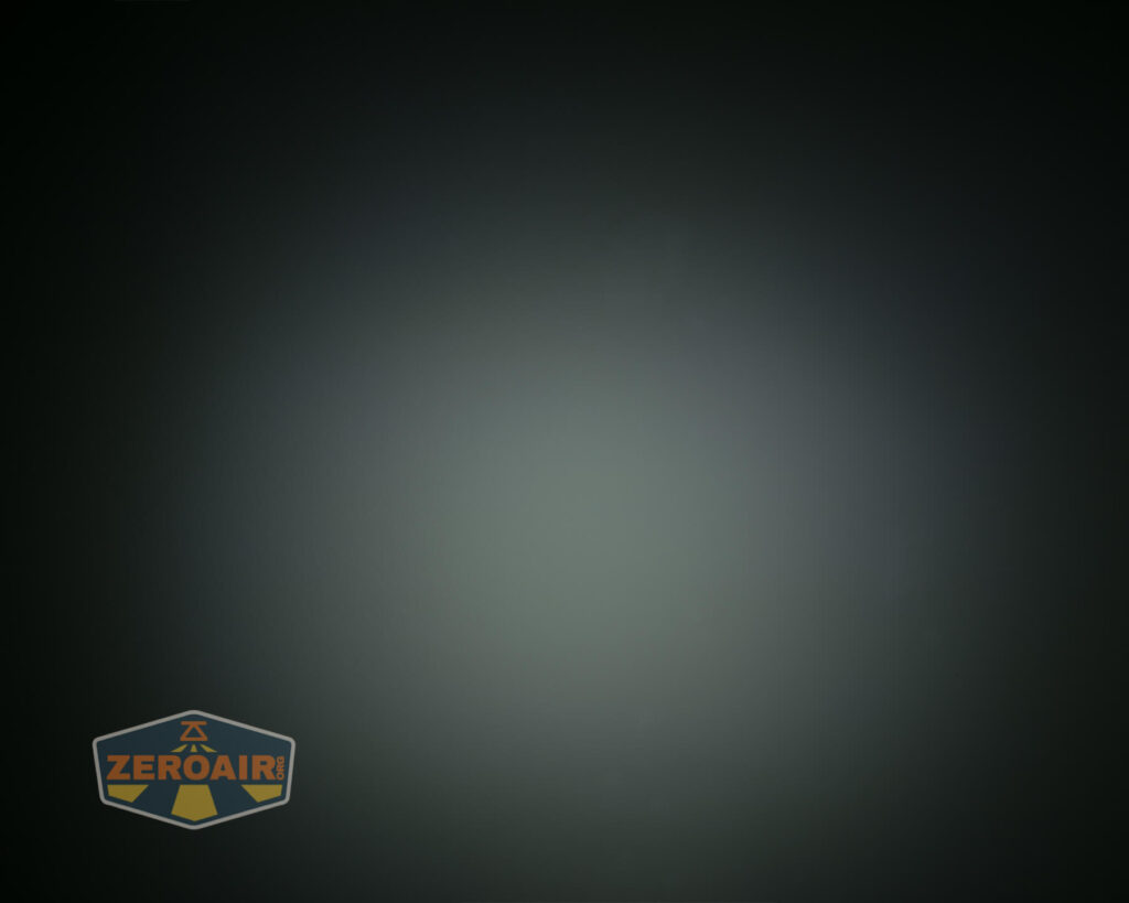 A dark, circular gradient fills the image with a soft light spot in the center. The lower left corner features a shield-shaped logo with the word ZEROAIR in orange text.