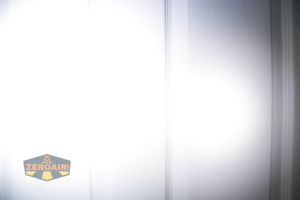 A brightly lit, white vertical surface with subtle panel lines. The ZeroAir logo is in the lower left corner.