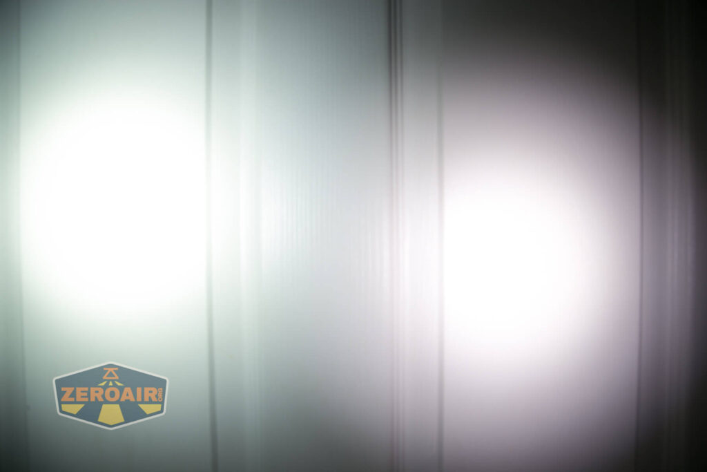 Two bright flashlight beams are projected onto a vertical white panel, with the left beam appearing slightly dimmer. The ZeroAir logo is visible in the bottom left corner of the image.