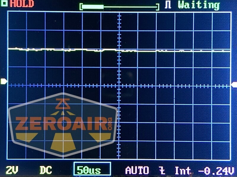 A digital oscilloscope screen shows a mostly flat yellow waveform near 0 volts. The horizontal scale is 50 microseconds per division, and the vertical scale is 2 volts per division. A ZeroAir logo overlays the lower left.