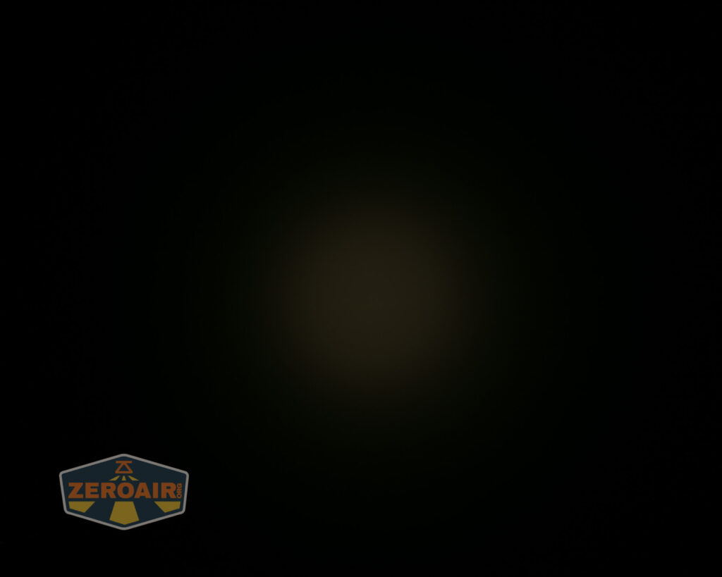 A mostly black image with a faint, dim circular light in the center. The bottom left corner features a ZeroAir logo with yellow and orange text on a dark background.