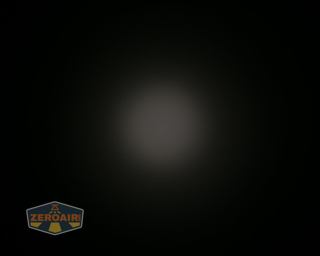 A dim, circular light spot appears in the center of a black background. In the lower left corner, there is a “ZeroAir” logo with a shield shape and yellow text.