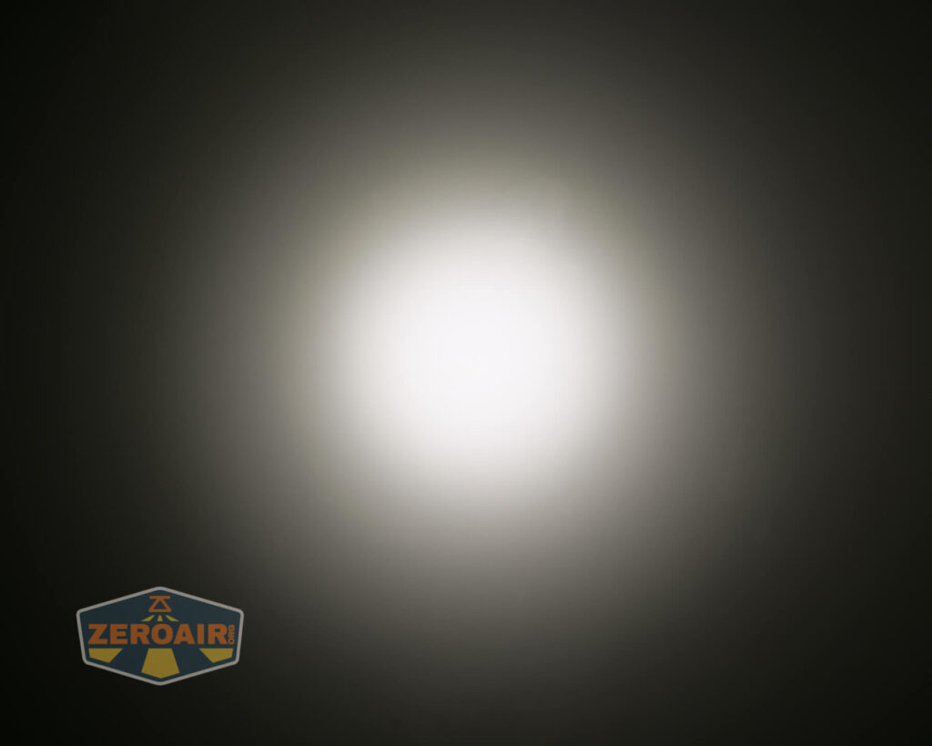 A bright white circular light shines in the center against a dark background. The light fades outward, creating a gradient halo effect. The ZeroAir logo appears in the lower left corner.