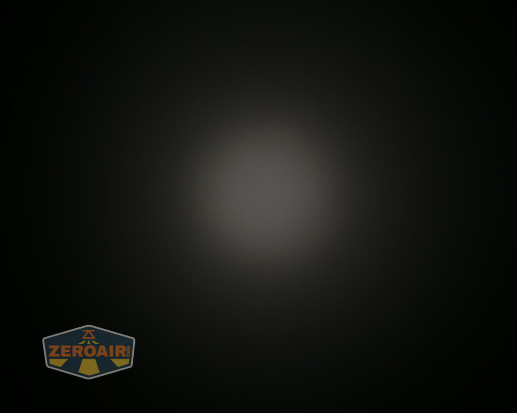 A dim, circular beam of light is centered against a dark background. The ZeroAir logo is visible in the bottom left corner.