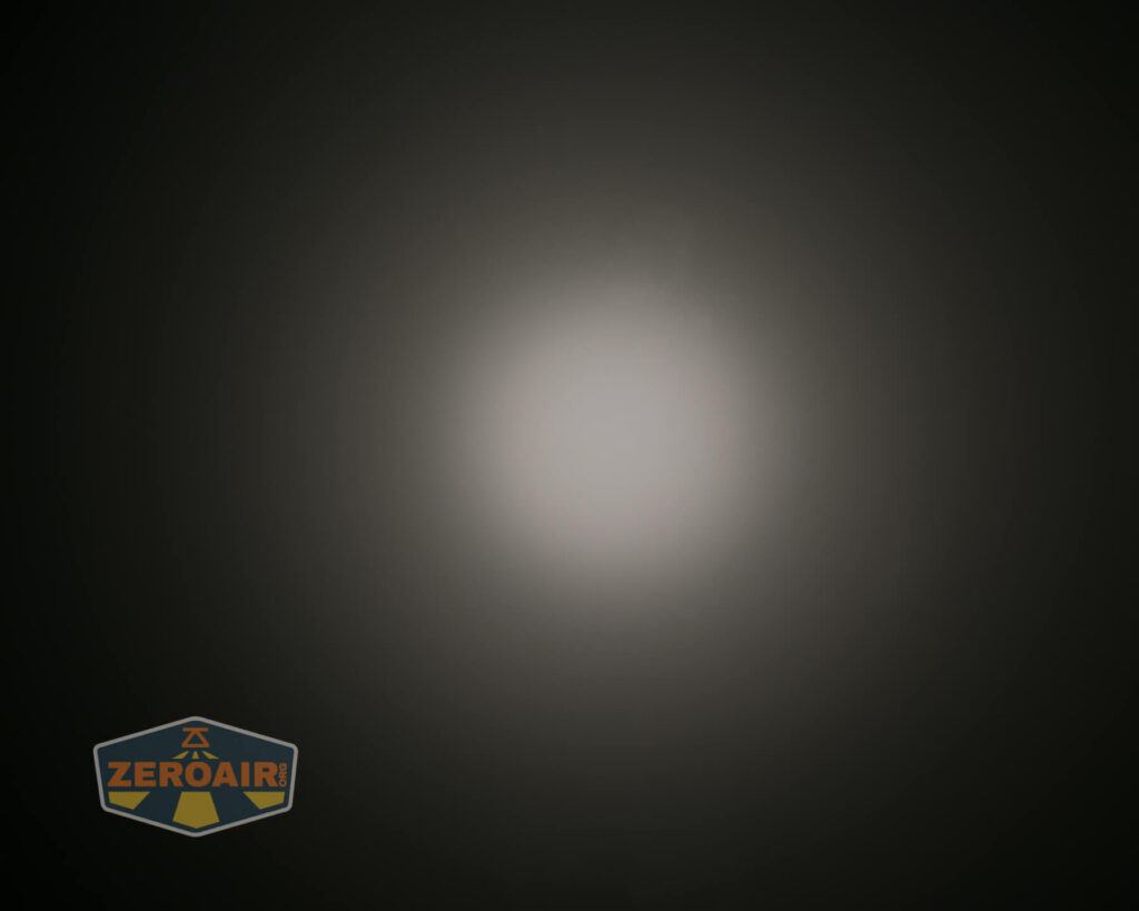 A circular white light beam appears against a dark background, gradually fading outwards. A ZeroAir logo is visible in the lower left corner of the image.