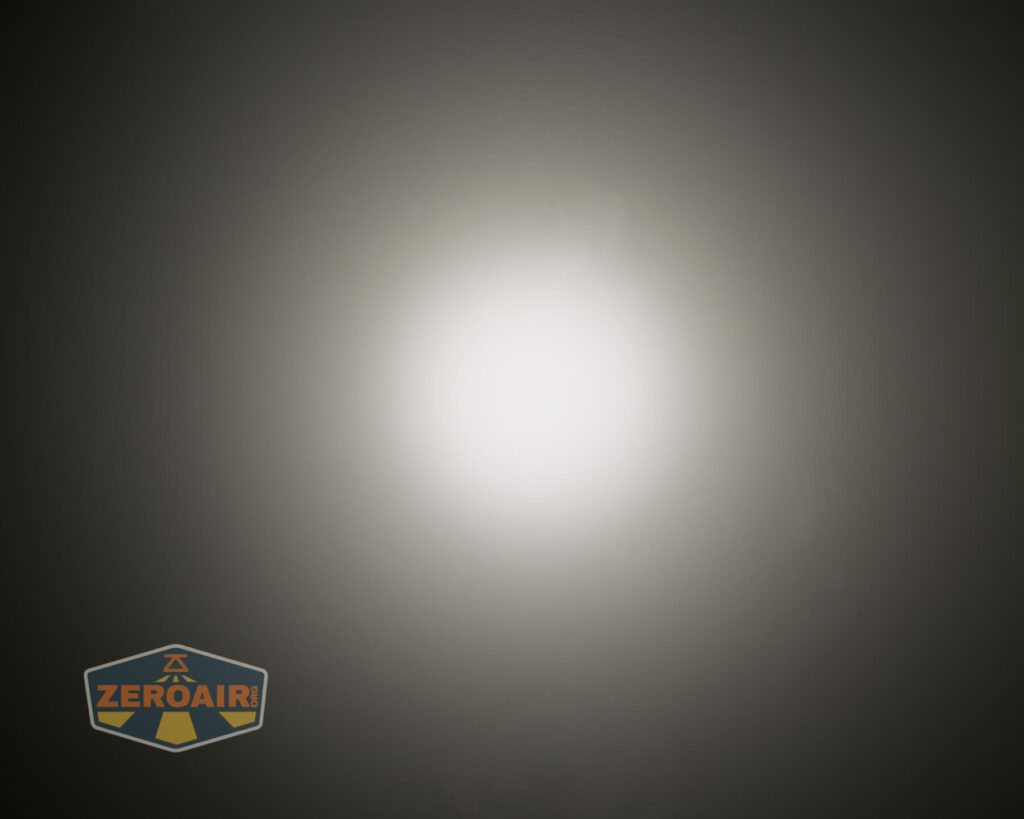 A bright, circular white light is centered on a dark gray background, creating a gradient effect. The ZeroAir logo appears in the lower left corner.