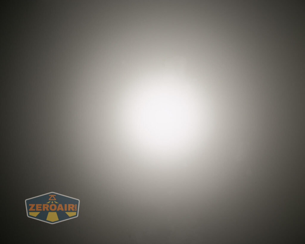 A bright white light is centered against a gradient gray background, creating a circular glow. A ZeroAir logo appears in the lower left corner.