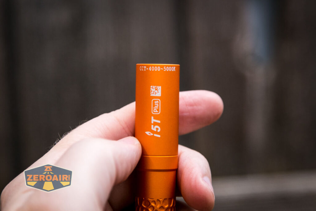 Olight i5T Plus Pebble flashlight showing logos in hand