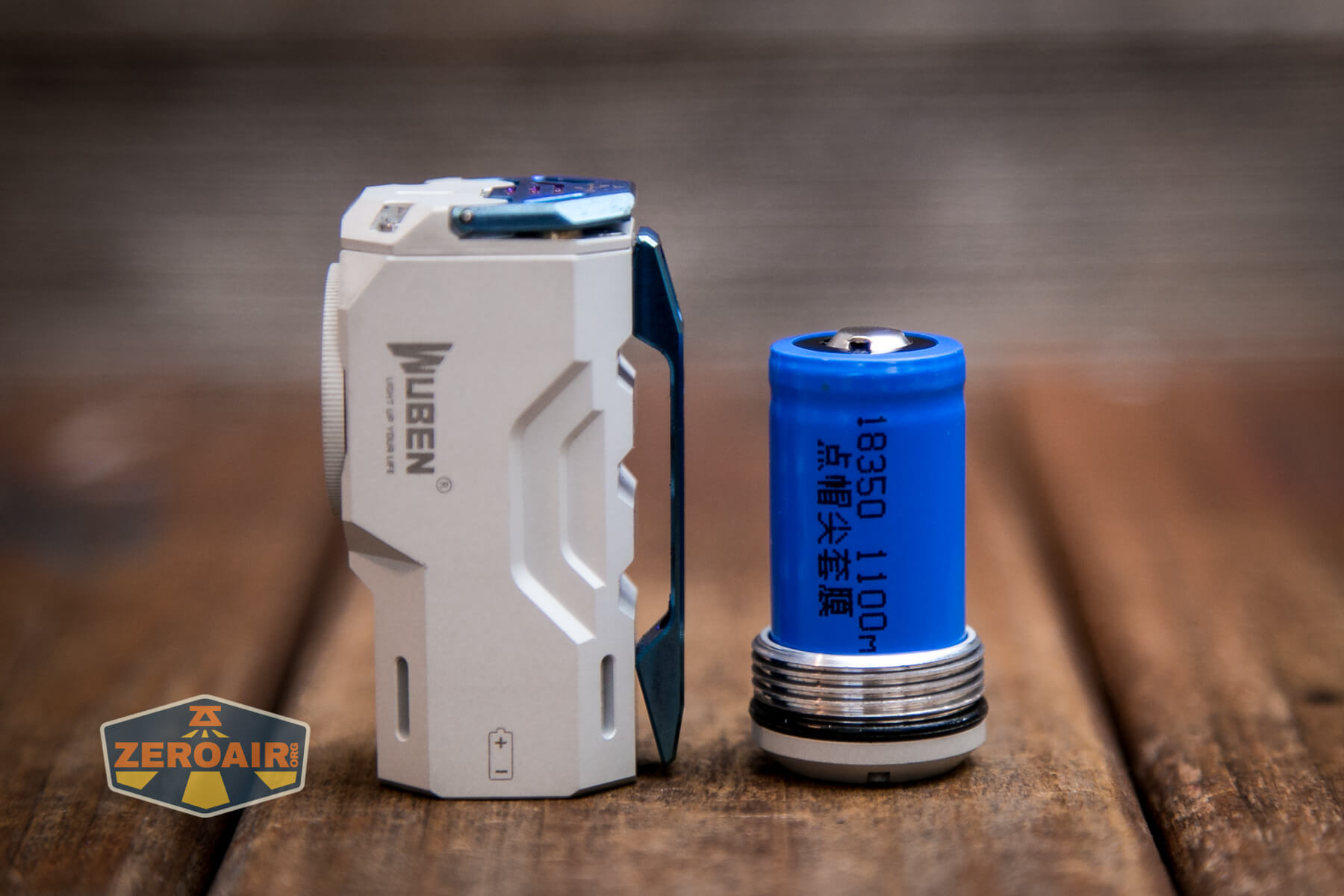 Wuben X-0 Knight flashlight beside cell