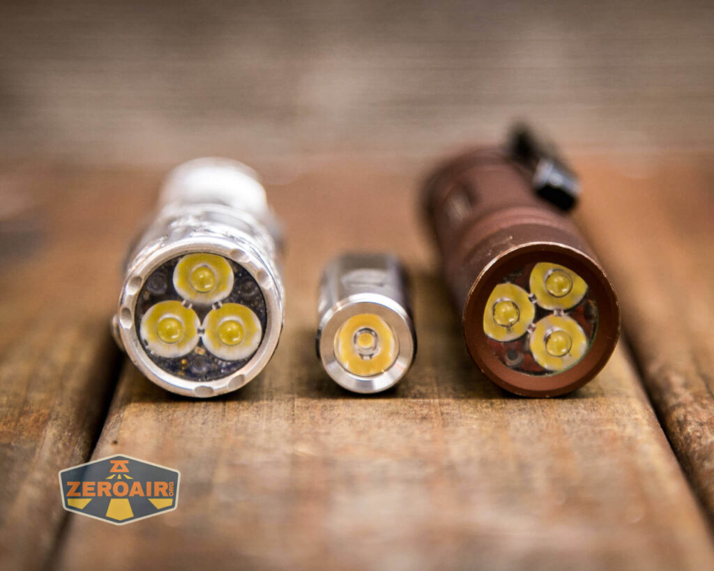 RovyVon Aurora A2 USB-C keychain flashlight beside the TorchLAB BOSS 35 (custom engraved) and beside the Convoy S2+ flashlight