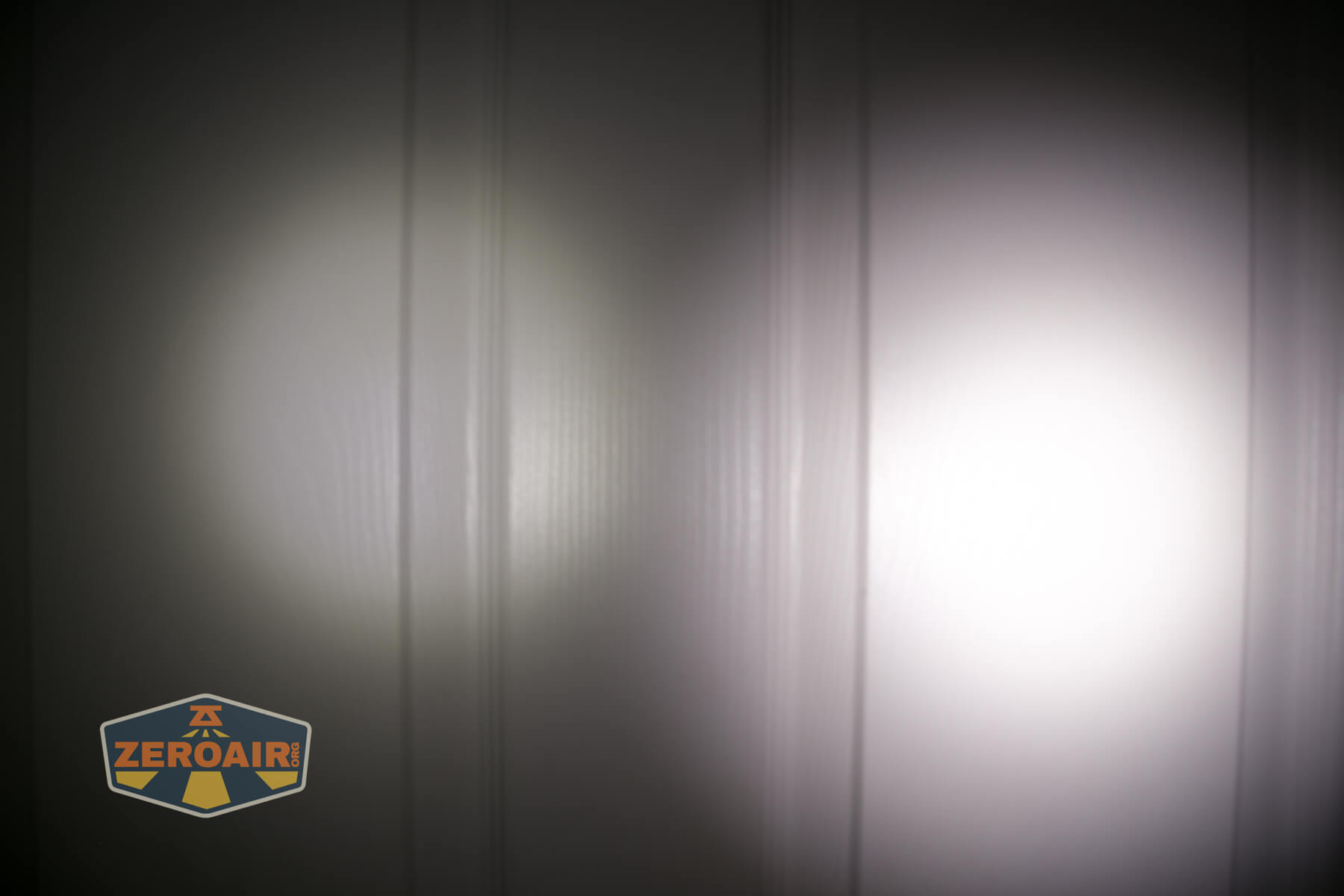Olight iMini Keychain Flashlight beamshot on door compared to nichia 219b