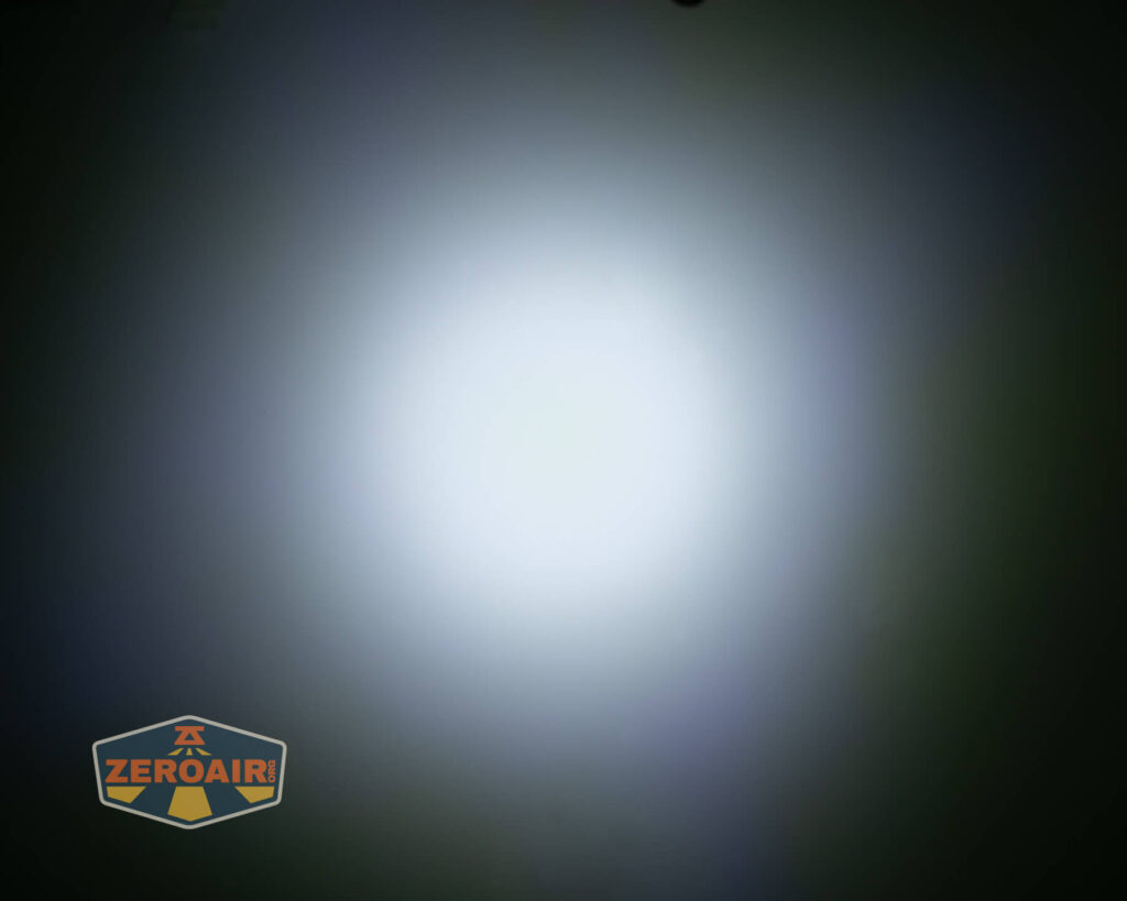 A circular, bright white beam of light is centered against a dark background. The ZeroAir logo appears in the bottom left corner of the image.