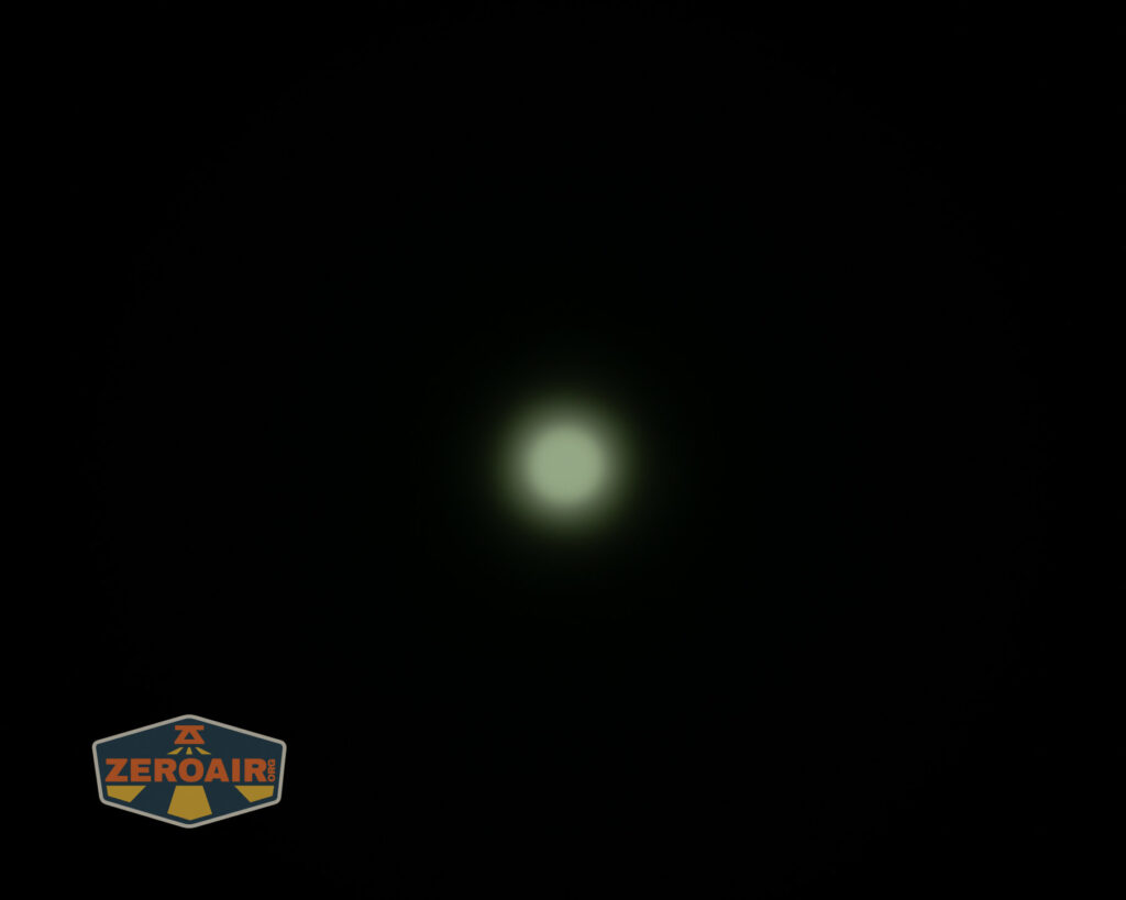 A faint, circular white light appears in the center of a black background. In the lower left corner, there is a shield-shaped logo with the word ZEROAIR on it.