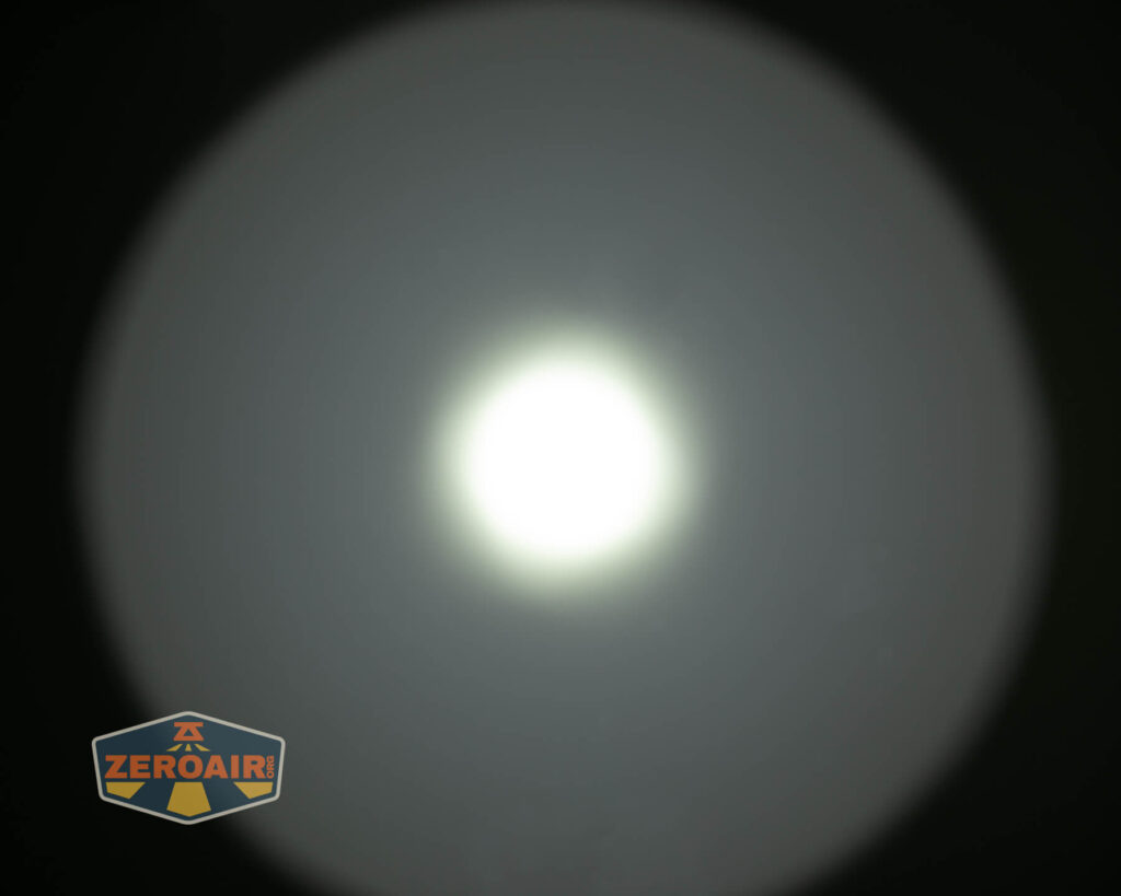 A bright white light is centered against a dark background, creating a circular halo effect. The ZEROAIR logo appears in the bottom left corner of the image.