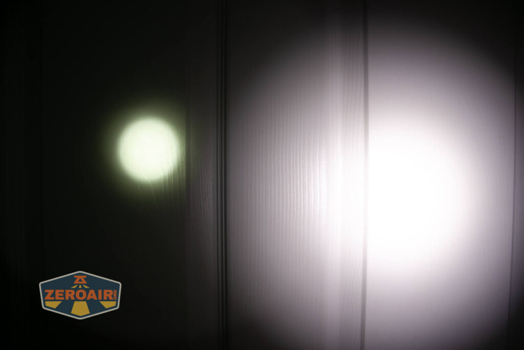 A dim, small circular beam of light appears on the left side of a textured surface, while a larger, brighter circular beam is on the right. The ZeroAir! logo is at the bottom left corner.