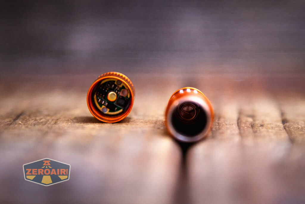 Olight i3E EOS Orange flashlight showing contacts and tail spring