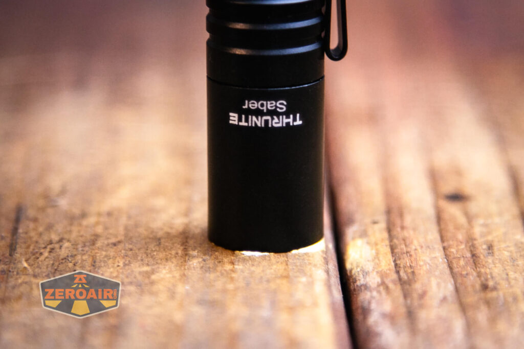 Thrunite Saber EDC pocket flashlight on and headstanding