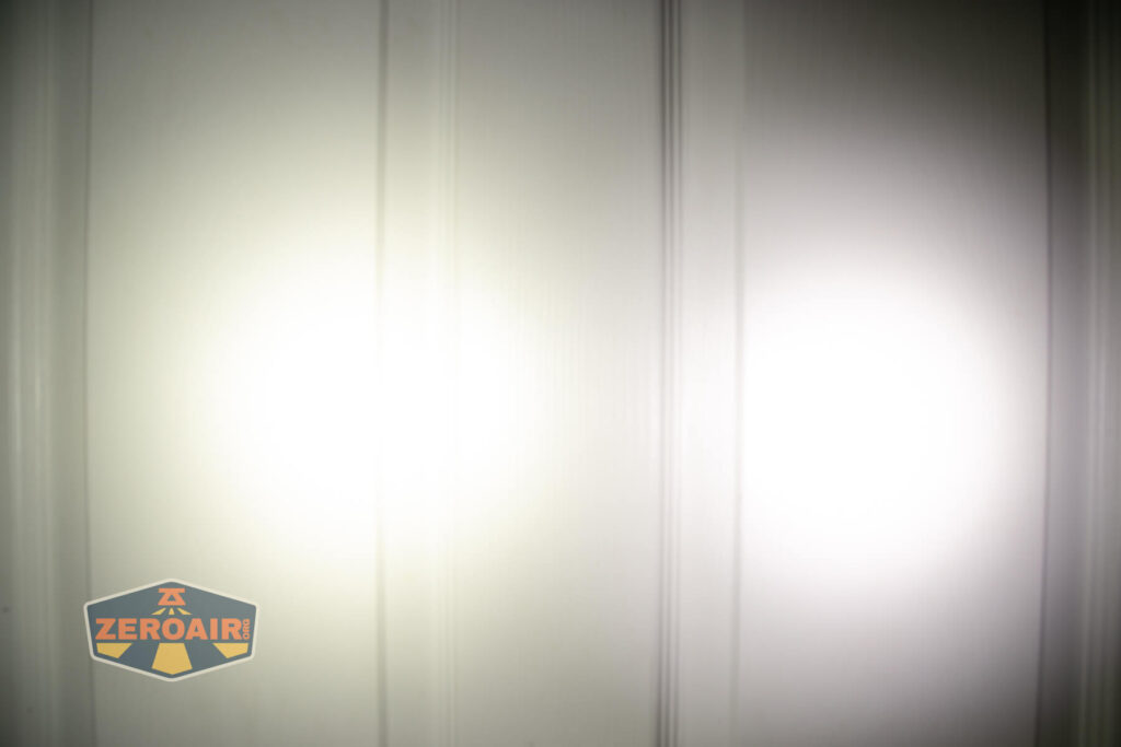 Two white light spots are projected onto a paneled white door, with the ZeroAir logo in the lower left corner of the image. The light beams overlap slightly in the middle.