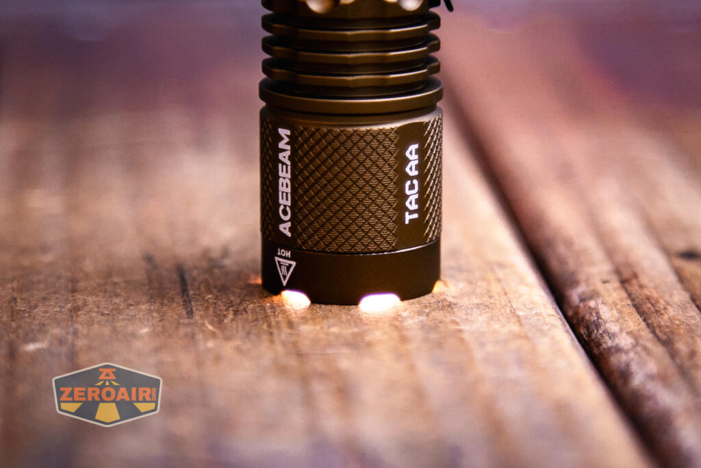 Acebeam TAC AA flashlight headstanding and on