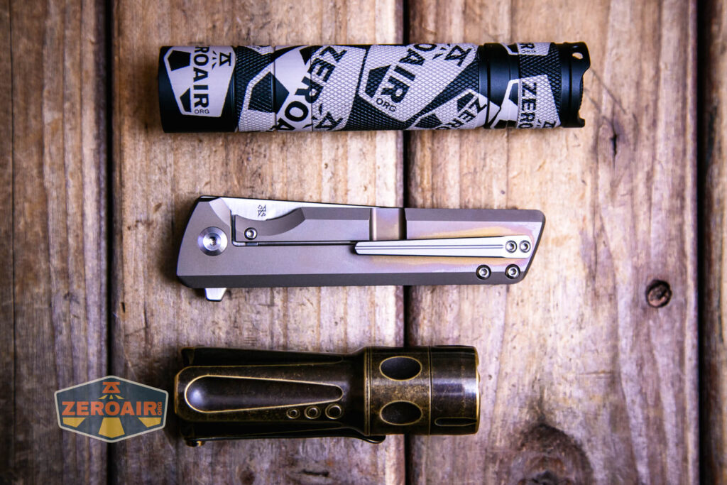 Kansept Anomaly titanium knife beside standard sized flashlights