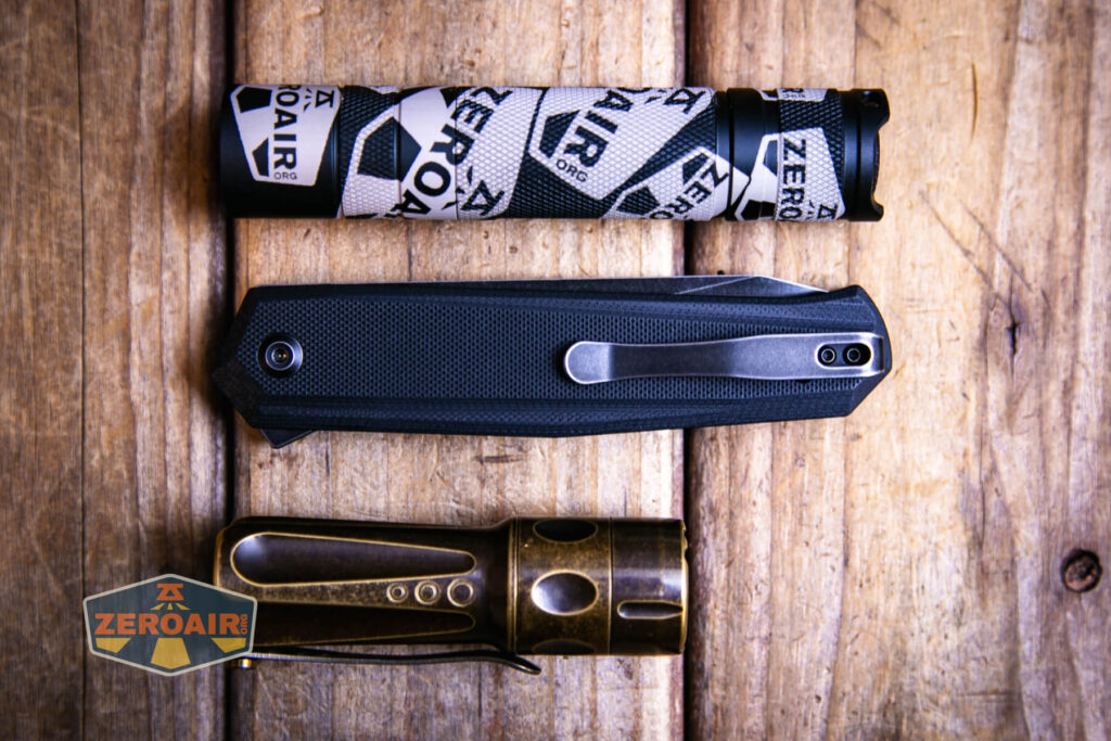 Kansept Integra flipper knife beside standard flashlights