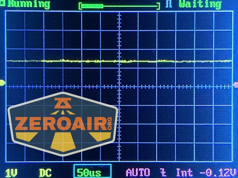 A digital oscilloscope screen displays a mostly flat yellow waveform. The settings show 1V DC, 50 microseconds per division. The ZEROAIR logo and a RovyVon E30 Pro MAO flashlight are visible in the lower left corner of the image.