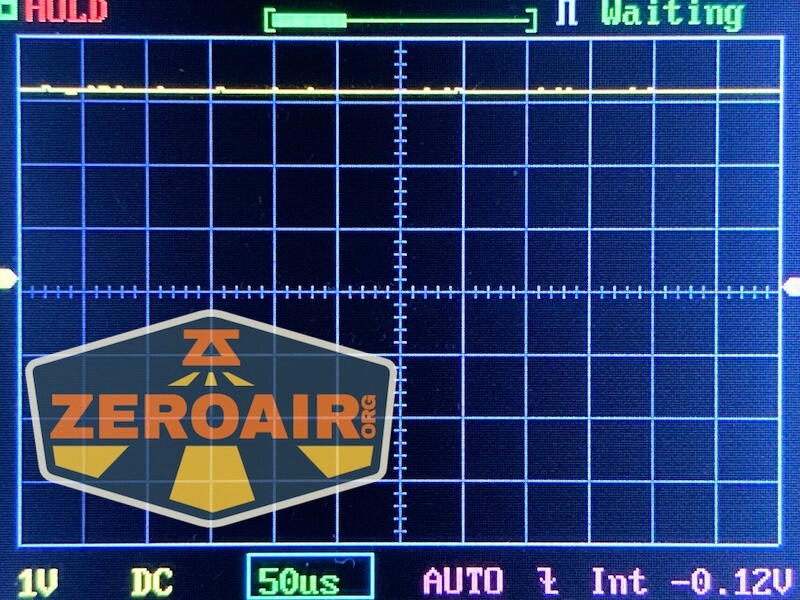 A digital oscilloscope screen displays a mostly flat yellow waveform with minimal noise. The display shows “HOLD,” “Waiting,” various settings, and a “ZeroAir.org” watermark, captured during RovyVon E30 Pro MAO flashlight output testing.